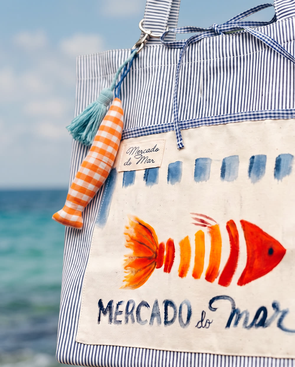 Detalhe do peixe pintado e do lettering Mercado do Mar, com o mar ao fundo