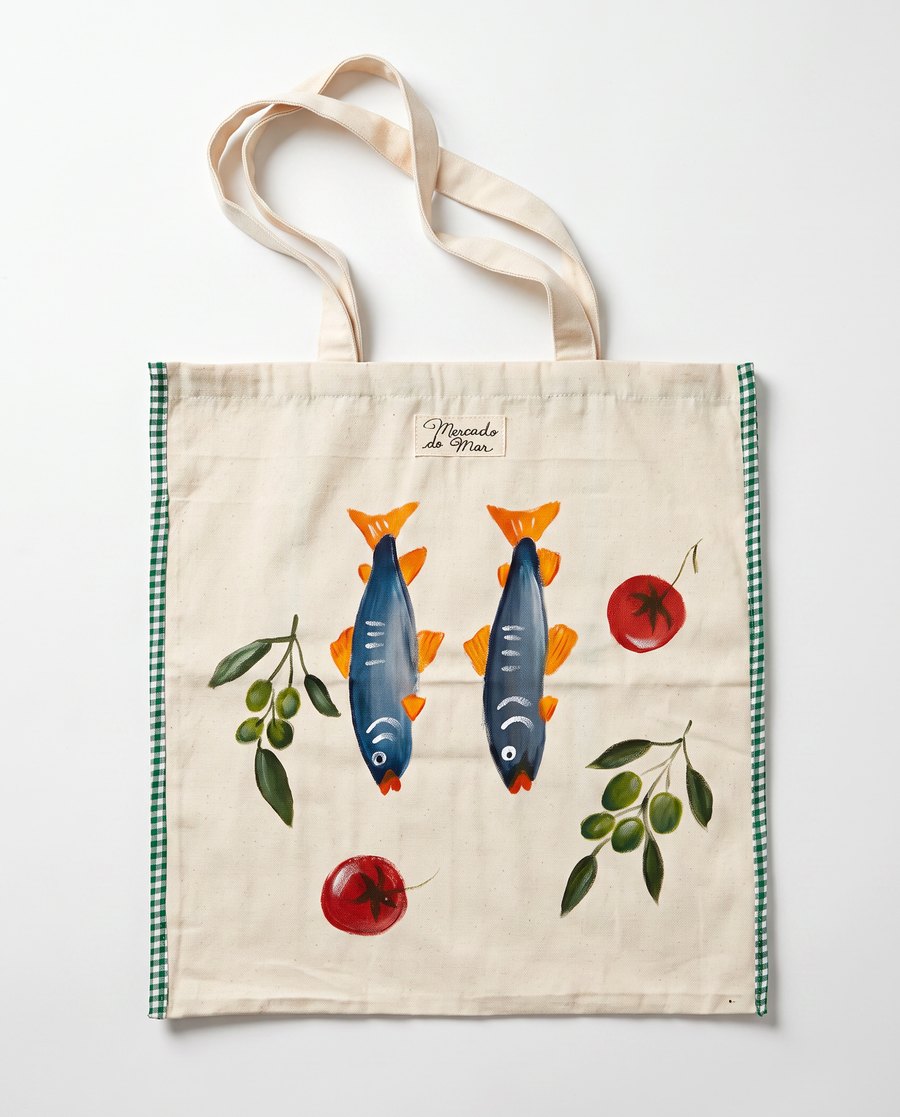 Bolsa O Tempero: duas sardinhas azuis de cauda laranja entre ramos de azeitona e tomates, com viés xadrez verde