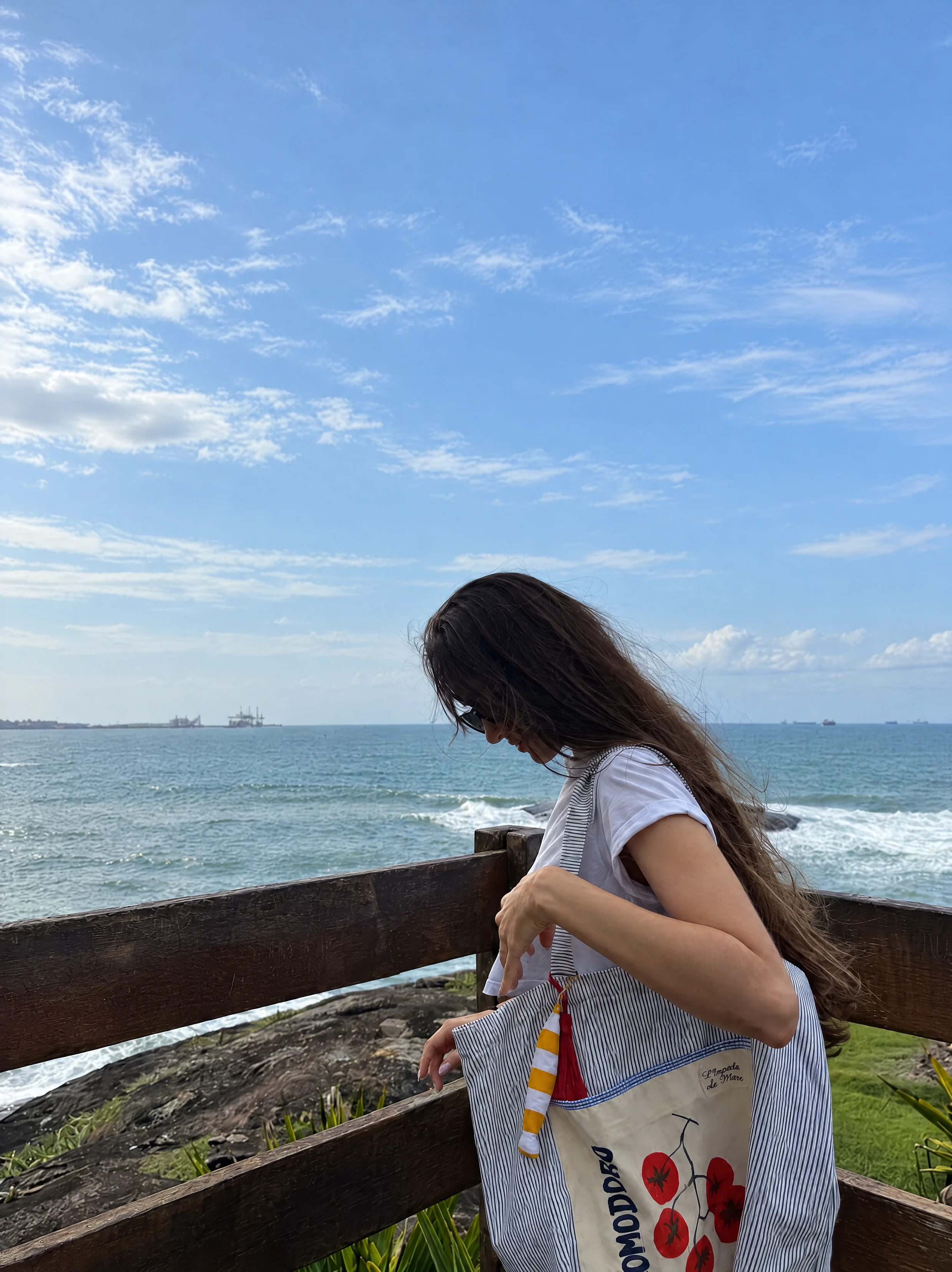 Bolsa Pomodoro no ombro, junto ao mar